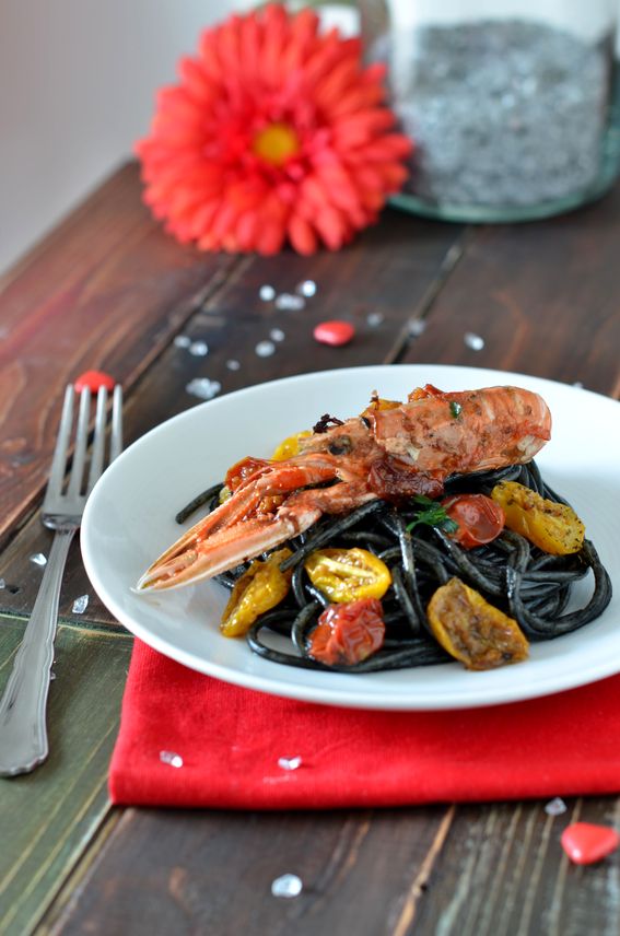 Spaghettoni al nero di seppia con pomodorini e scampi.