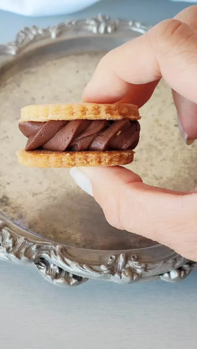 Biscotti di pasta frolla sablè con ganache al cioccolato montata 🥰
Dire che amo la ganache montata è riduttivo ma voi l’avete mai provata? 😎
Perfetta per farcire biscotti come ho fatto io, decorare muffin, cupcake o torte a strati o da ricoprire😎
.
Una farcitura perfetta per questi biscotti di frolla sablè 
Pronti a realizzarli anche voi? 
.
Pasta frolla per biscotti: 
300 gr di farina 00
170 gr di burro
100 gr di zucchero semolato
60 gr di tuorlo
1 pizzico di sale
.
Ganache:
200 gr di cioccolato fondente
150 gr di panna fresca
50 gr di burro
.
Disponiamo la farina a fontana
Mettiamo al centro il burro freddo a tocchetti
Sfreghiamo con le mani fino ad ottenere un impasto sabbiato
Aggiungiamo lo zucchero, poi i tuorli e alla fine il pizzico di sale.
Amalgamiamo tutto
Avvolgiamo con pellicola e lasciamo riposare il panetto in frigo per 1 oretta.
Riprendiamo l’impasto.
Lo stendiamo con una mattarello su un piano appena infarinato 
Se avete difficoltà potete anche stendere l’impasto tra due fogli di carta da forno 
A questo punto con uno stampo tondo formiamo tanti cerchi
Andiamo avanti e realizziamo i biscotti fino a terminare la frolla
Lasciamo riposare i biscotti in frigo per ancora 1 ora (oppure in freezer per mezz’ora)
Trascorso questo tempo di riposo accendiamo il forno a 200 gradi modalità statica.
Inforniamo prima un solo biscotto così da controllare il tempo di cottura esatto.
Io ho infornato a 200 gradi per circa 10/12 minuti.
Andiamo avanti con la cottura di tutti gli altri biscotti.

Preparazione ganache: 
Nel frattempo prepariamo la ganache
Quindi tagliamo il cioccolato con un coltello.
In una pentola scaldiamo la panna 
Non appena calda togliamo dal fuoco e aggiungiamo il cioccolato. 
Mescoliamo con l’aiuto di una frusta a mano fino ad ottenere una crema omegenea, a questo punto inseriamo il pezzettino di burro.
Mescoliamo ancora e poi copriamo con pellicola a contatto.
Facciamo raffreddare bene 
Riprendiamo la ganache  e la frulliamo con le fruste elettriche in modo da montarla perfettamente. 
Una volta freddi farciamo con la confettura la base del biscotto e poi copriamo con il cuore bucato.
Prima di servirli distribuiamo zucchero a velo